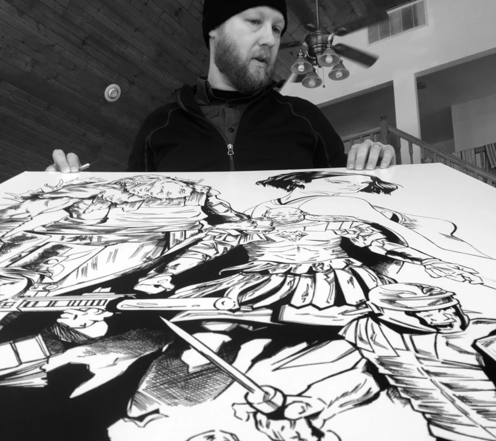 Elijah Loving inking a large comic page